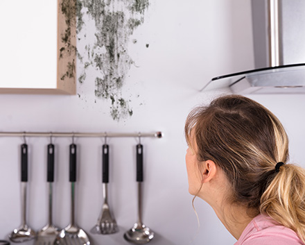 Woman Looking at Mold on Her Walls Wondering if That Is What Is Making Her Sick