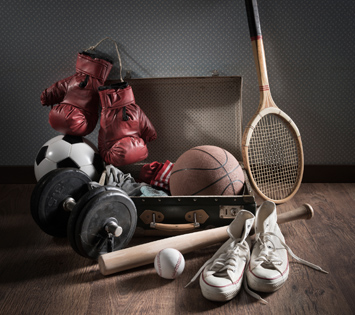 A Set of Dumbells, Baseball and Bat, Tennis Racket, Basketball, Boxing Gloves and Sneakers on the Floor